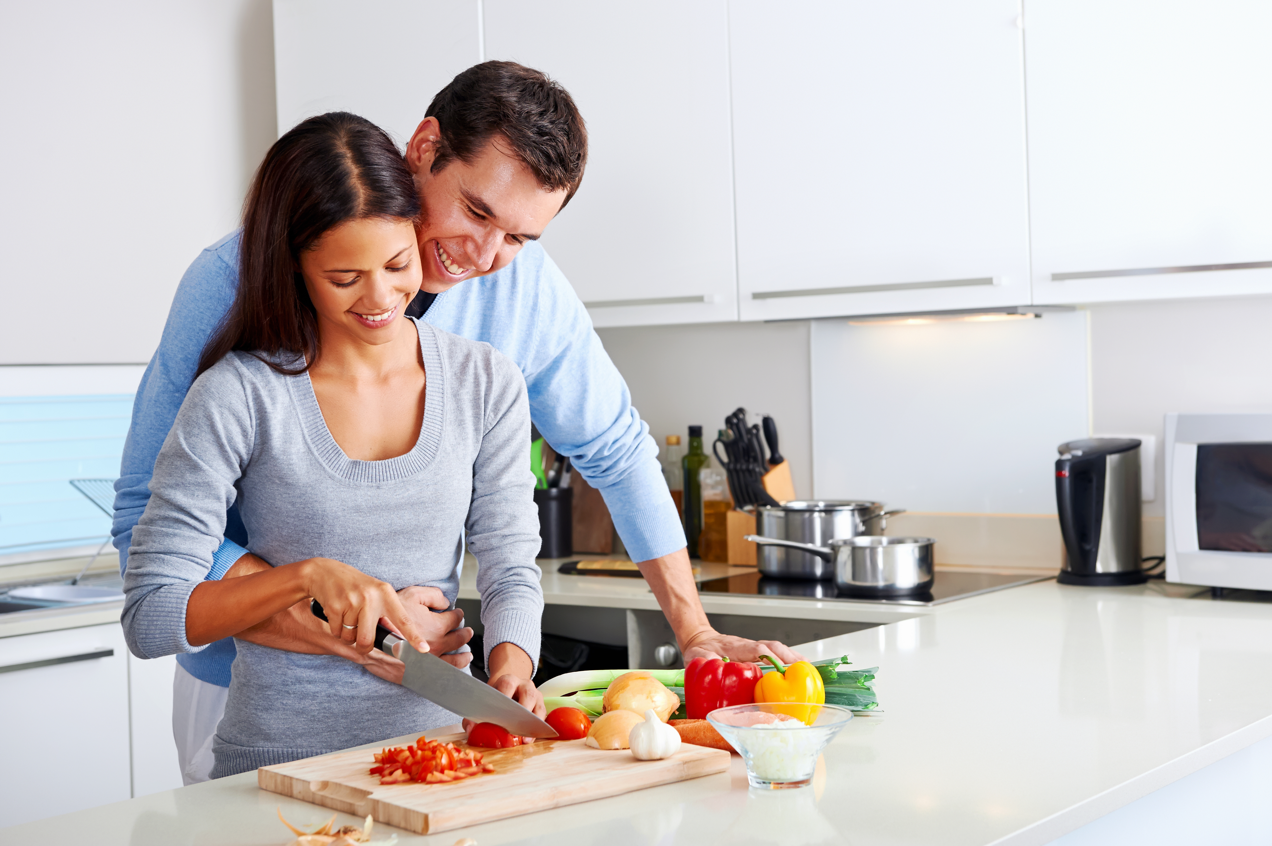Муж помогает вставлять жене. Счастливая семья на кухне. Готовим вместе. Готовка на кухне. Пара на кухне.